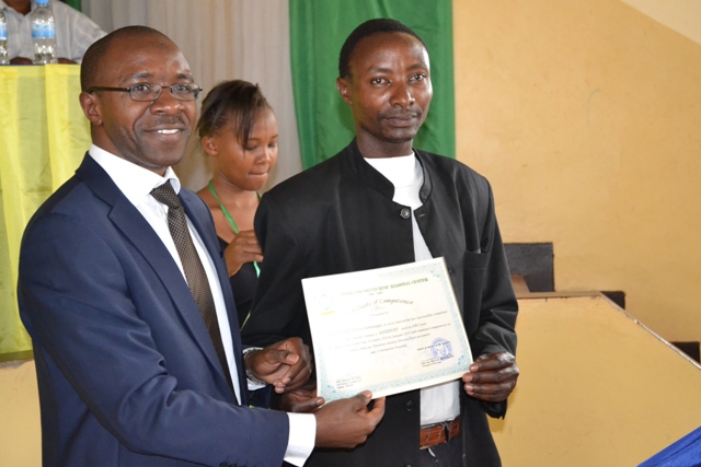 Umuyobozi wa IPRC East Dipl.-Eng. Ephrem Musonera (ibumoso) aha umwe mu banyeshuri impamyabushobozi