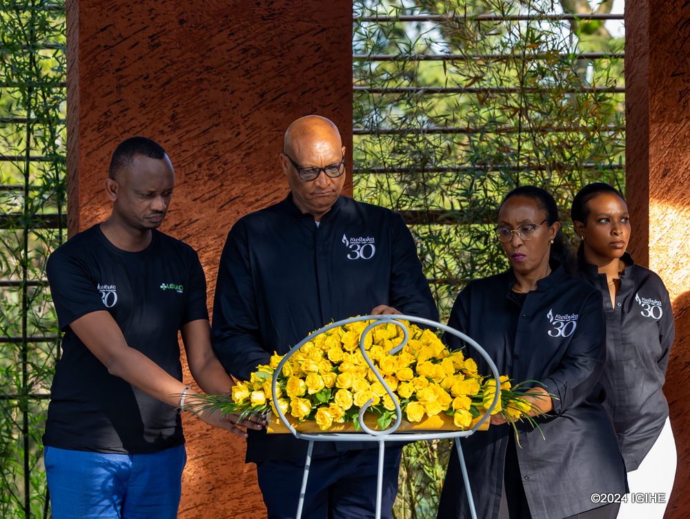 Umuyobozi Mukuru wa Legacy Clinics, Jean Malic Kalima ashyira indabo ku mva ishyinguwemo abarenga ibihumbi 250 mu Rwibutso rwa Jenoside rwa Kigali ruri ku Gisozi
