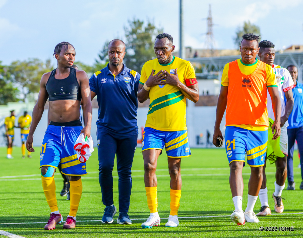 Muhire Kevin (ibumoso) agana mu rwambariro aganira n'Umutoza wongera imbaraga Mwambari Serge na Kapiteni Kagere Meddie (hagati) na Nsabimana Aimable (iburyo)
