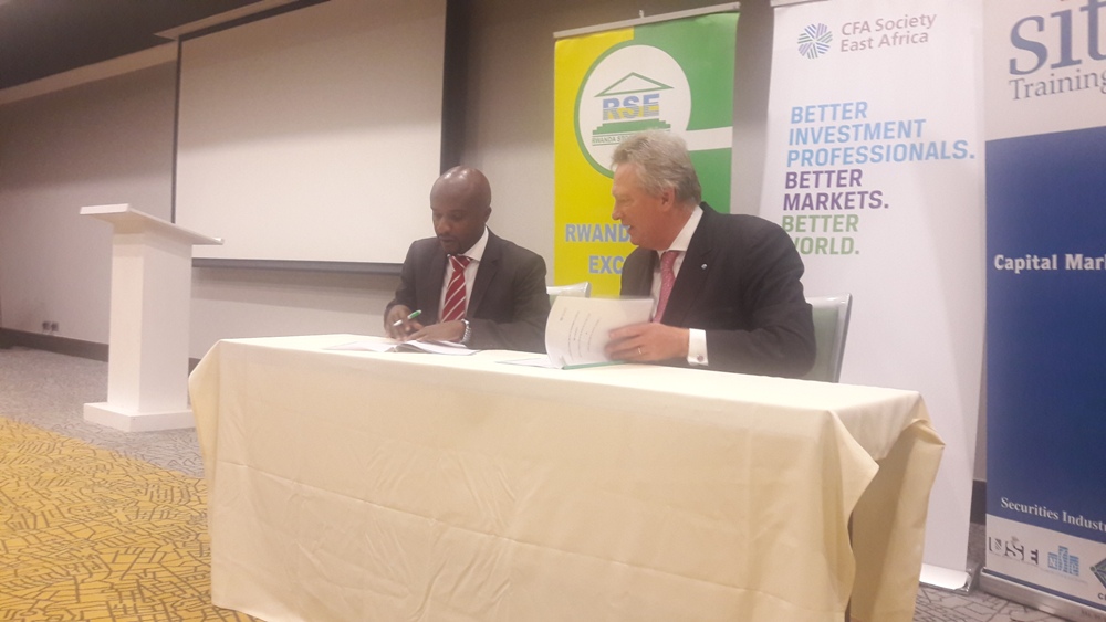 Perezida akaba n’Umuyobozi Mukuru w’Ikigo cya CFA, Paul Smith n’uw’Ikigo cy’Imari n’Imigabane mu Rwanda (Rwanda Stock Exchange-RSE), Pierre Célestin Rwabukumba, bashyira umukono ku masezerano