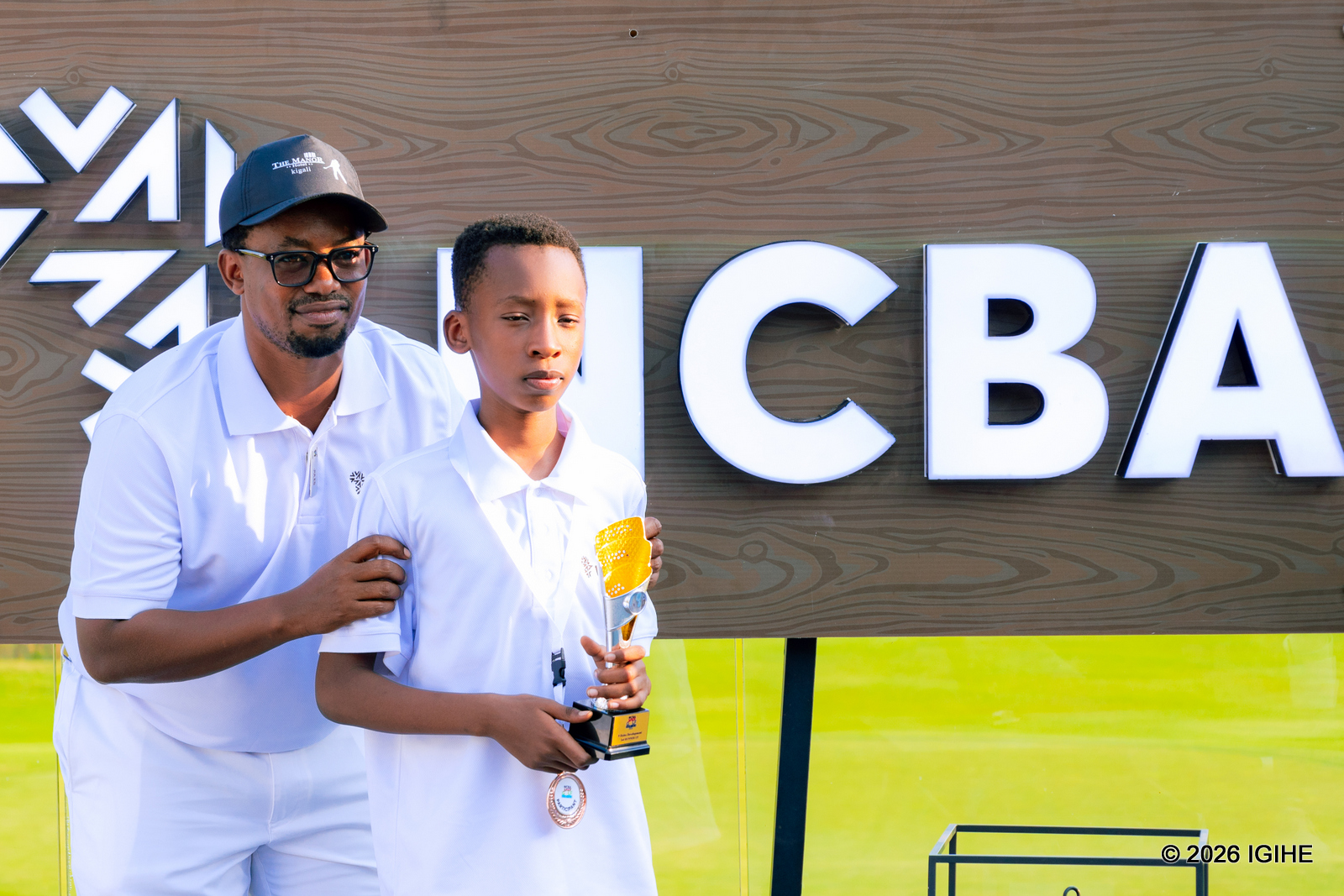 Umutoza w'abana muri Kigali Golf Rsorts & Villas, Dusabe Jules, ahemba umwe mu bana bitwaye neza