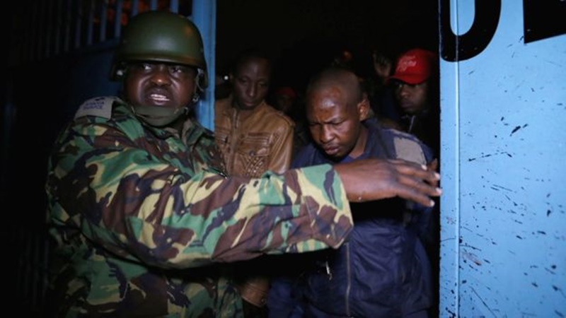 Umusirikare afungurira abitabiriye amatora kugira ngo binjire ku biro by'itora