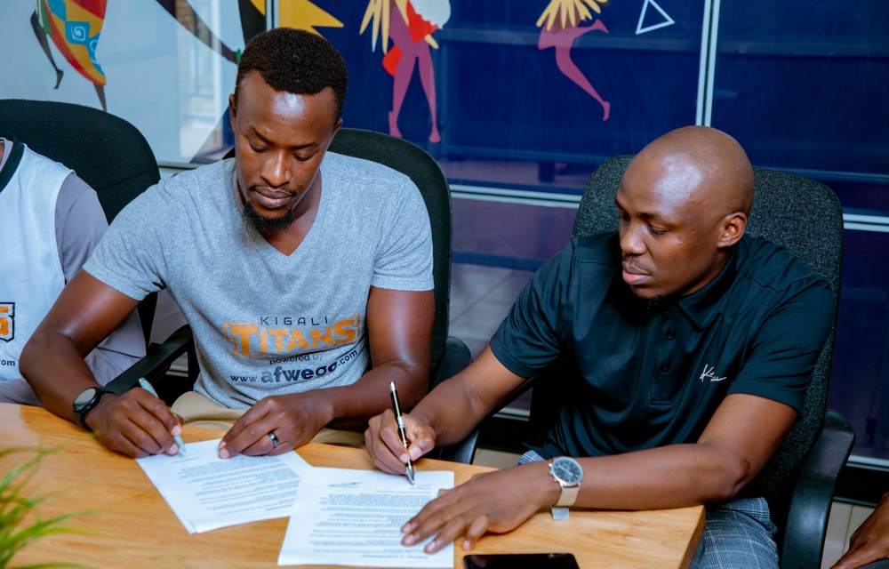 Umuyobozi wa Kigali Titans, Rubonera Eugène (ibumoso) na Nelson Nwankwo ushinzwe ibijyanye na Tekiniki muri Afwego Inc bashyira umukono ku masezerano y'imikoranire afite agaciro ka miliyoni 30 Frw
