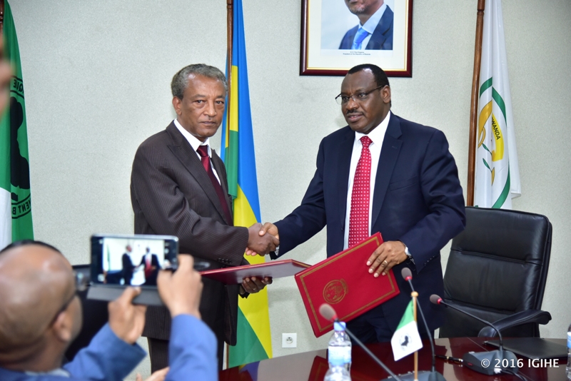 Negatu Makonnen, uhagarariye AFDB mu Rwanda na Minisitiri w’Imari n’Igenamigambi, Amb. Claver Gatete bahererekanya amasezerano nyuma yo kuyashyiraho umukono