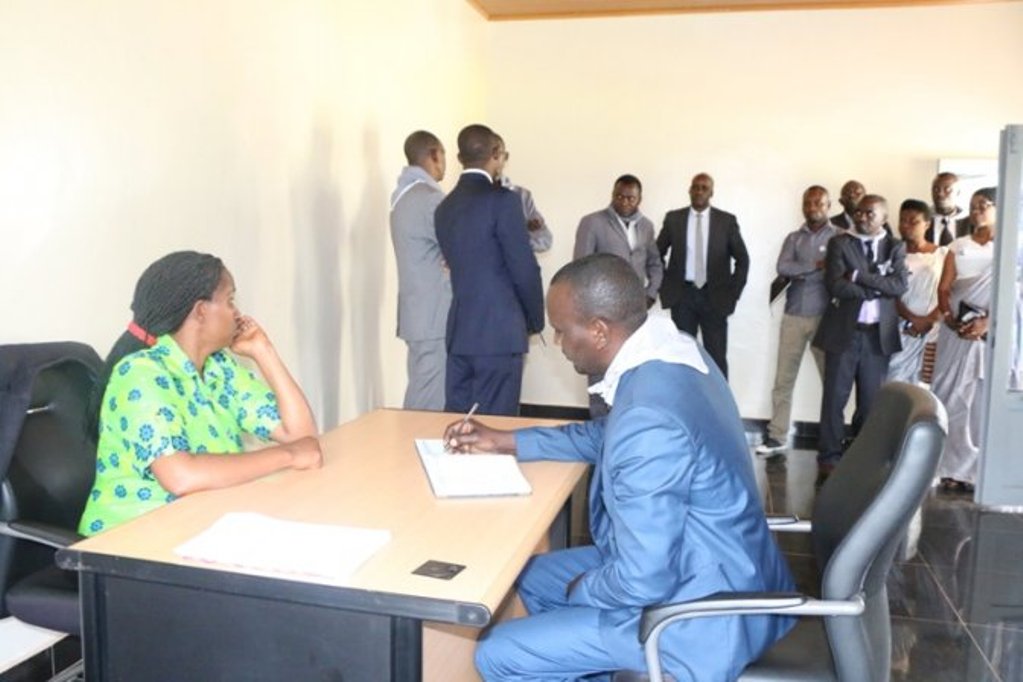 Umwe mu bayobozi yandika ubutumwa mu gitabo cy'abashyitsi