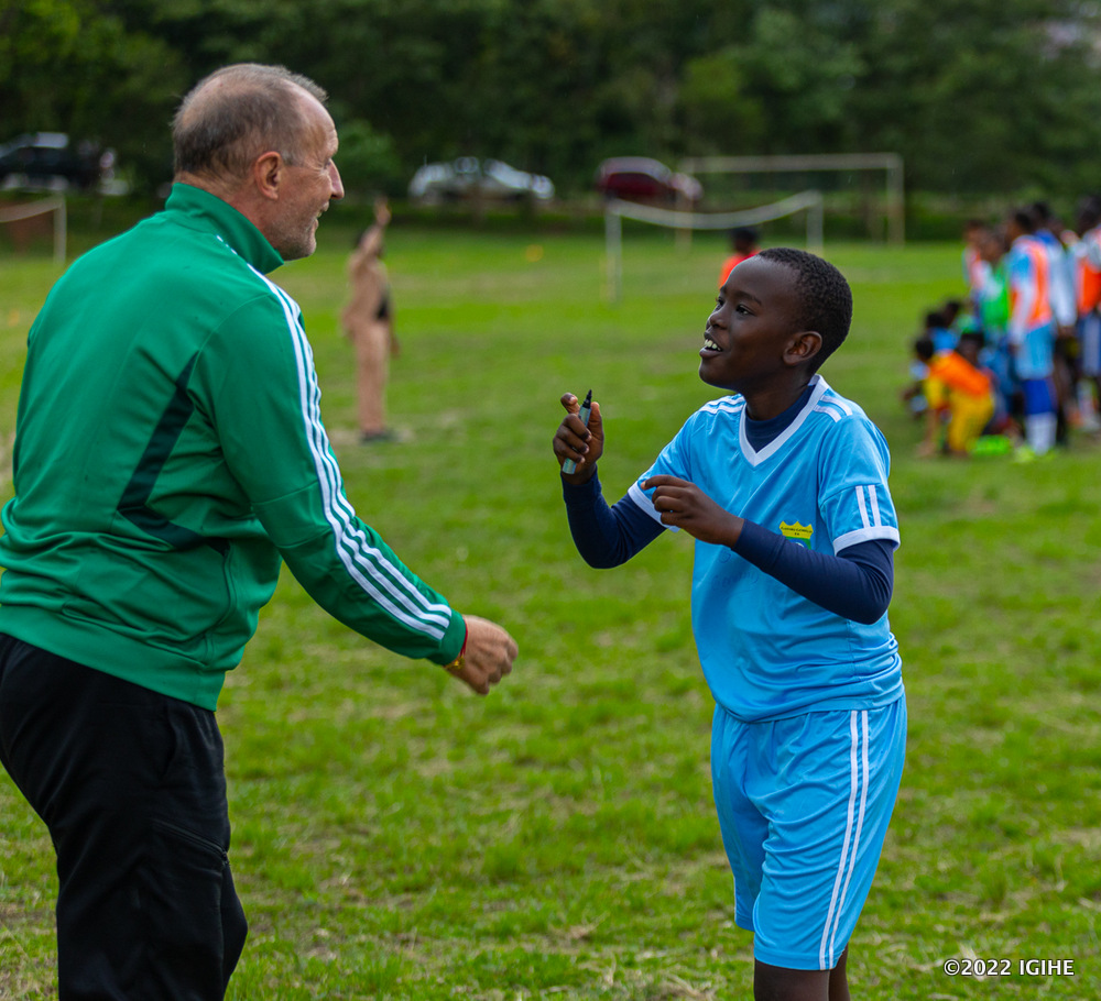Yannis umwe mu bana batozwa gukina umupira w'amaguru muri Gasabo Gorilla Football Academy asaba Directeur Gérad Buscher ko yamusinyira ku mwenda we