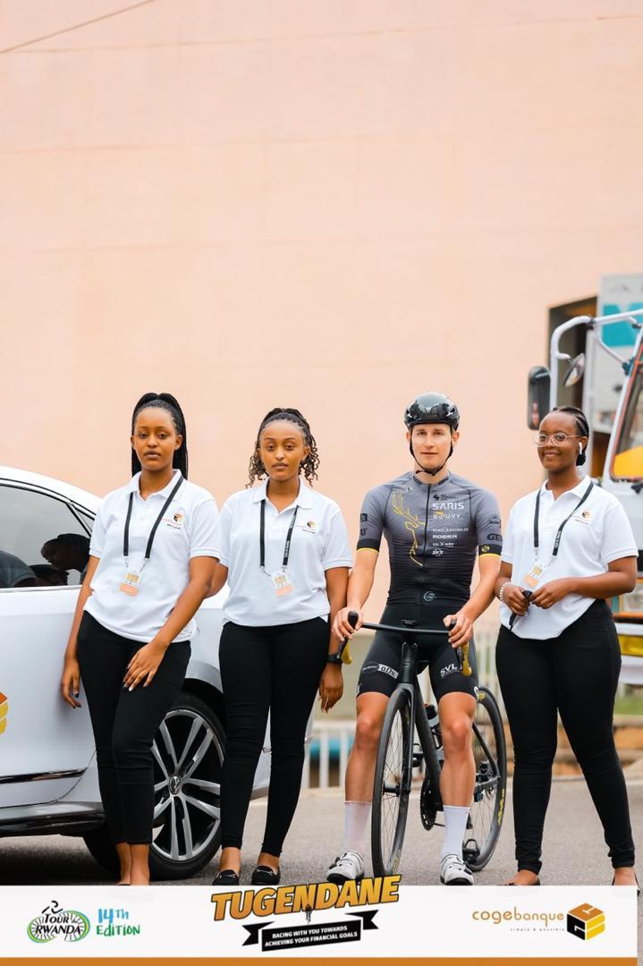 Abakobwa baherekeje Cogebanque bafata ifoto y'urwibutso n'umwe mu bakinnyi bitabiriye Tour du Rwanda 2022