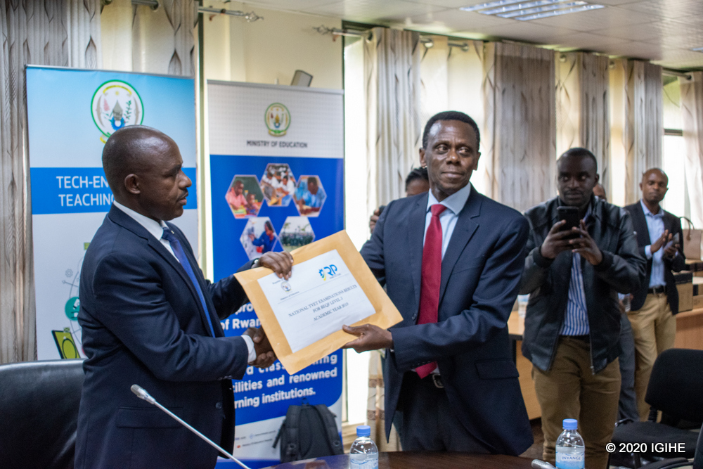 Umuyobozi w'ishuri rikuru ry'imyuga n'ubumenyingiro, Dr Gashumba James (iburyo) ahereza amanota y'abakoze ibizami mu myuga n'ubumenyingiro