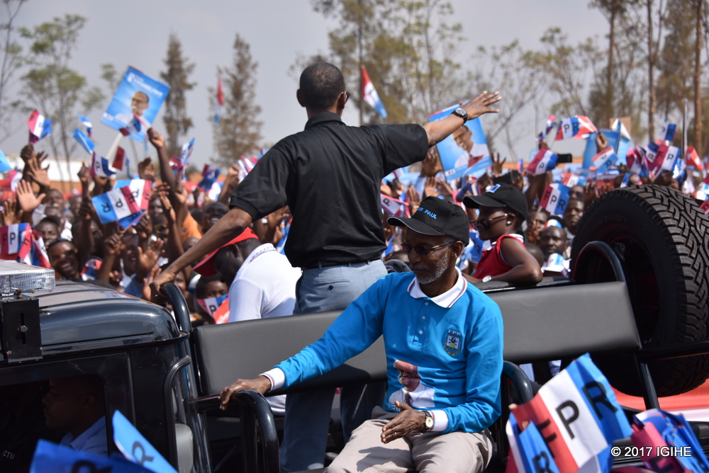 Paul Kagame agaragiwe n'Umunyamabanga Mukuru w'Umuryango wa FPR Inkotanyi, Ngarambe François ubwo yageraga i Nyamirambo yazengurutse asuhuza abahateraniye