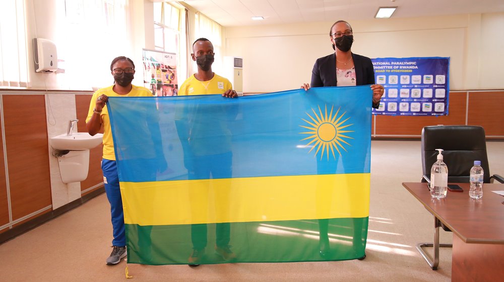 Minisitiri wa Siporo, Munyangaju Aurore Mimosa (iburyo) ubwo yashyikirizaga ibendera Muvunyi Hermas (hagati) na Mukobwankawe Liliane (ibumoso)