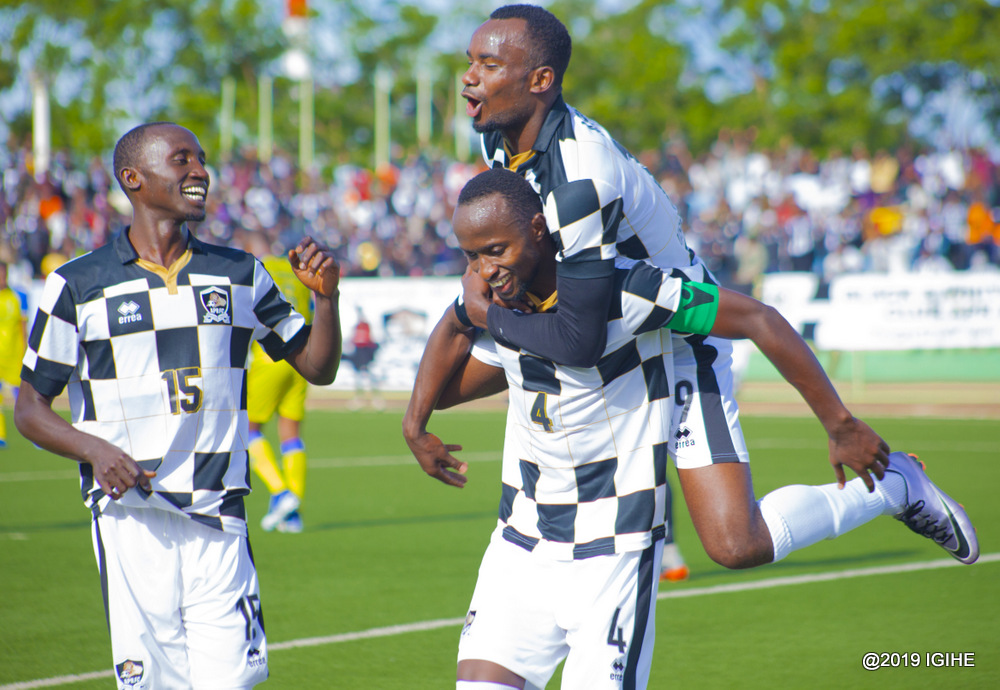 Manzi Thierry wari Kapiteni wa APR FC yishimira igitego yatsinze AS Muhanga mu mukino wa Shampiyona y'umwaka wa 2019/20. Aha yari ahetse Usengimana Danny mu gihe Bukuru Christophe ari kubareba hirya gato n'akanyamuneza