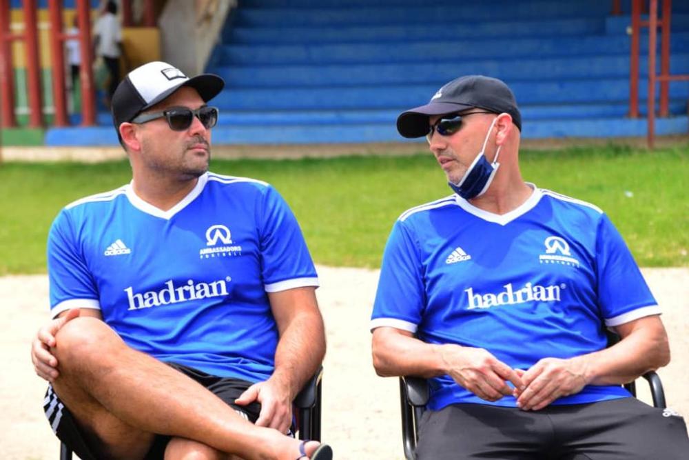 Perezida wa Ambassadors Football, Jonathan Ortlip (wambaye agapfukamunwa) na Dr Aaron Tredway umwungirije mu gikorwa cyo gutangiza ishuri riteza imbere impano z’abana mu mupira w’amaguru mu Karere ka Nyamagabe