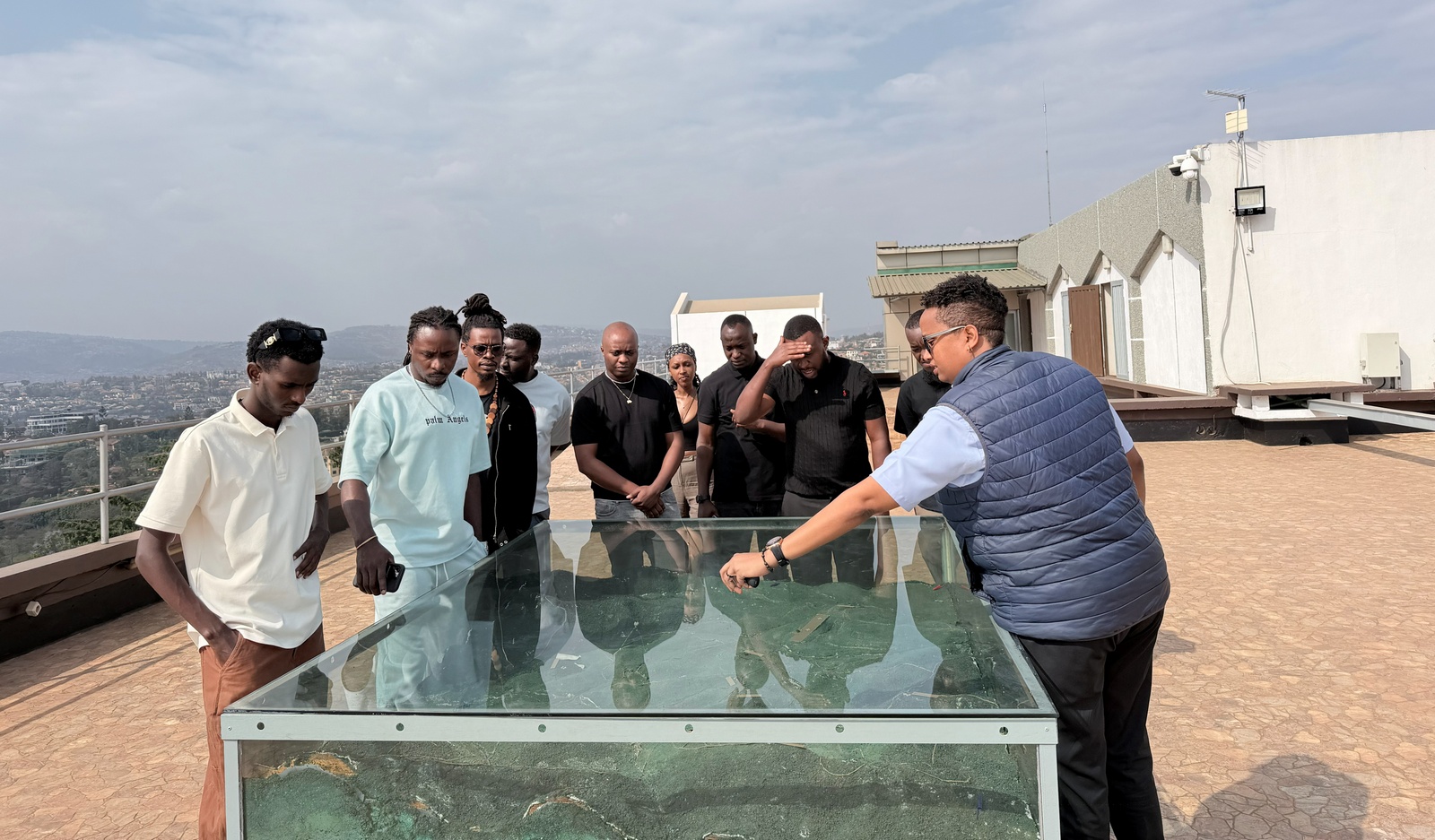 Kuri iyyi foto, King James n'abo bari kumwe basobanuriwe uko urugamba rwo kubohora Umujyi wa Kigali rwagenze