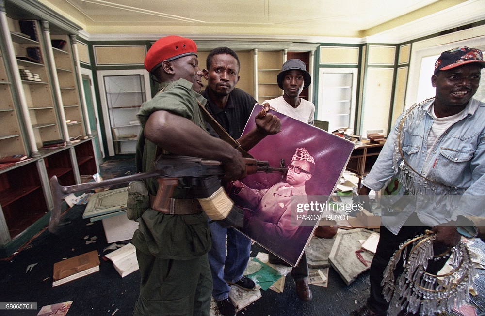 Umusirikare mu ngabo za Kabila ubwo yatungaga imbunda ifoto ya Mobutu bamaze gufata Kinshasa