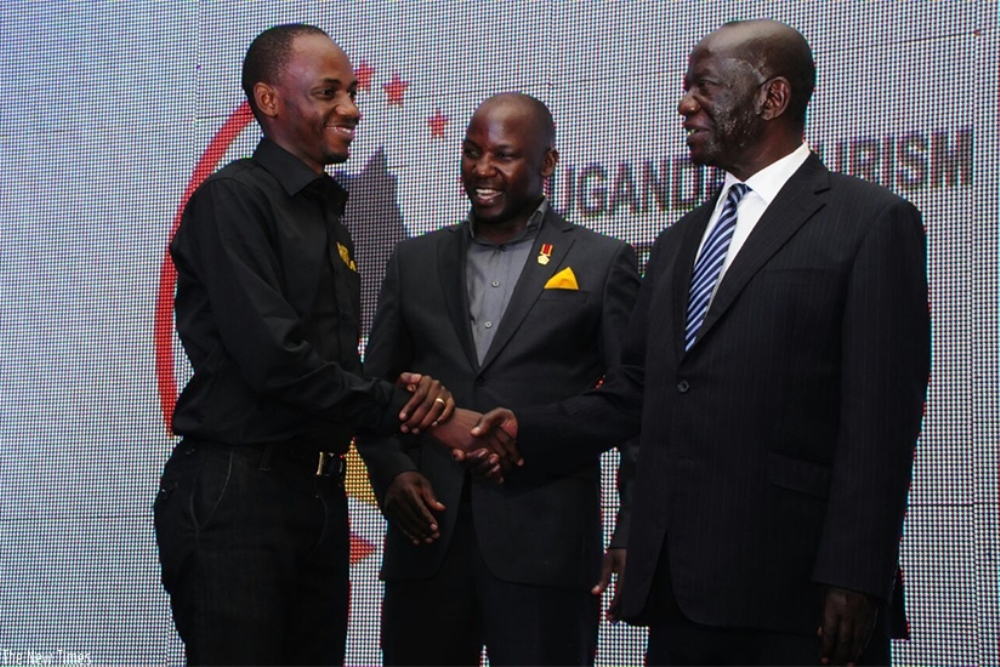 Ndandali Philbert (Ibumoso) wari uhagarariye RDB ashimirwa na Visi Perezida wa Uganda Edward Kiwanuka Sekandi, Umunyamabanga wa Leta ushinzwe ubukerarugendo muri Uganda, Godfrey Kiwanda (hagati)/Ifoto: Gashegu Muramira