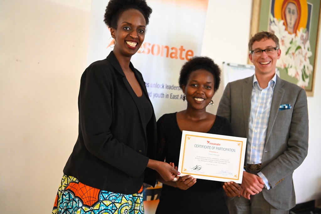 Uwera Desange (hagati) wize mu Agahozo Youth Village yishimiye ubumenyi yungukiye mu mahugurwa. Aha yashyikirizwaga impamyabushobozi n'abarimo Umuyobozi wa Resonate mu Rwanda, Norette Turimuci (ibumoso) n'uhagarariye Ambasade ya Leta Zunze Ubumwe za Amerika