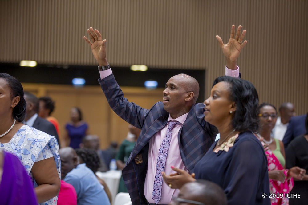 Apôtre Ndagijimana Joshua Masasu uyobora Evangelical Restoration Church yazamuye amaboko aha icyubahiro Imana. Ari kumwe n'umugore we Pasiteri Lydia Masasu