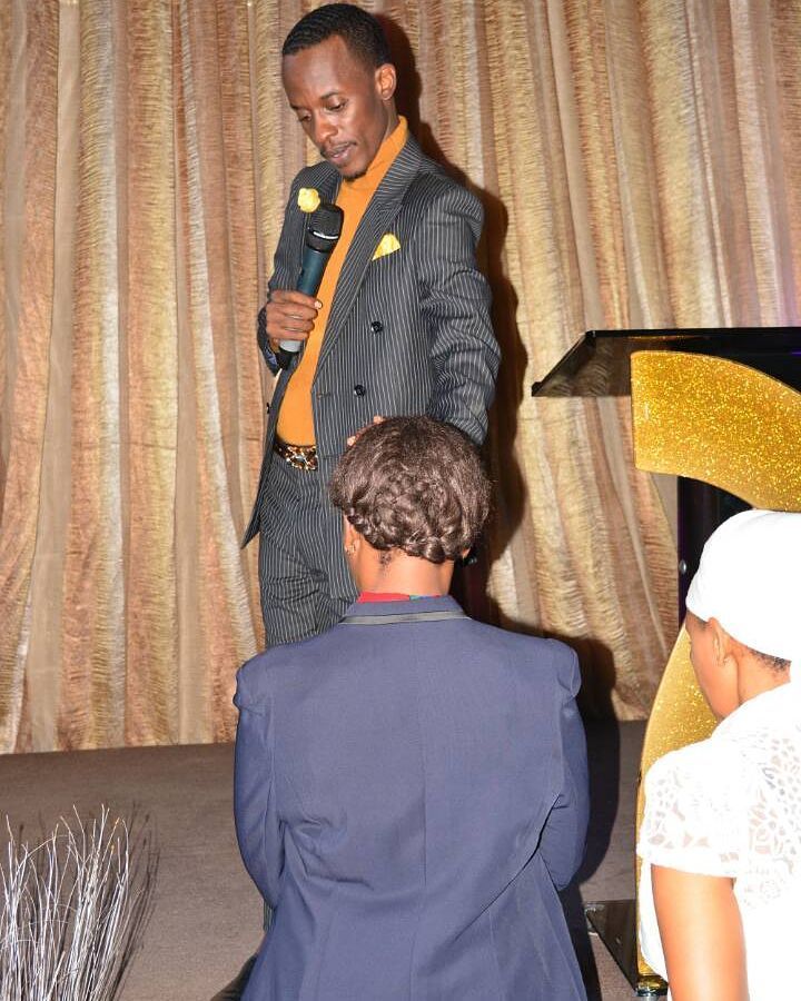 Prophet Eric arambika ikiganza kuri umwe mu bayoboke be, amusengera