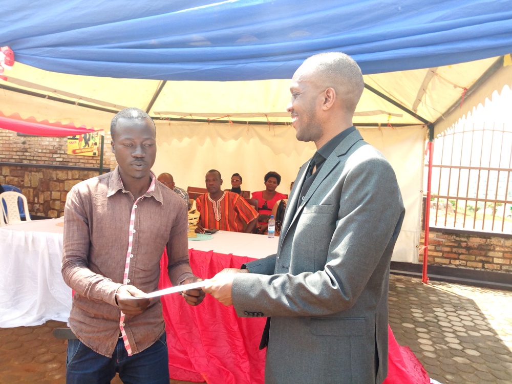 Umuyobozi wa KPC, Philippe Gatete, atanga inyemezabumenyi kuri umwe mu basore bahize