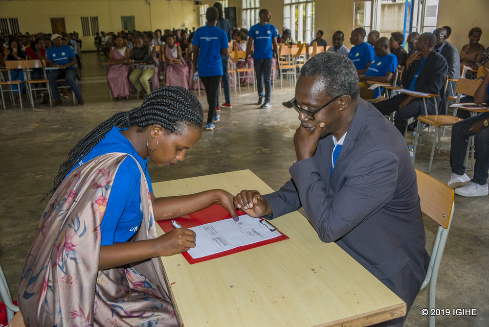 Uwineza ari gushyira umukono ku mihigo bahize